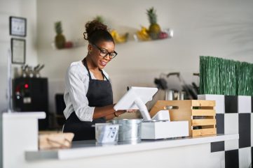 friendly-african-american-shop-assistant-using-pos-terminal-to-input-orders-at-restaurant.jpg